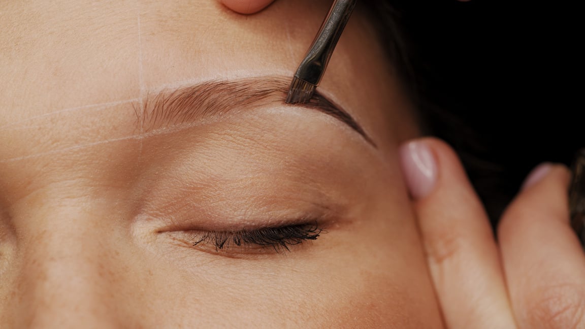 Woman Is  on the Eyebrow Coloring Procedure. Professional Lamina